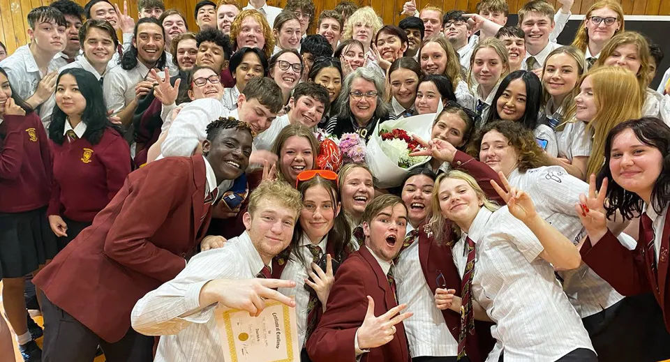 Un grande gruppo di studenti e studentesse del Heretaunga College posa insieme in divisa scolastica per una foto di gruppo.