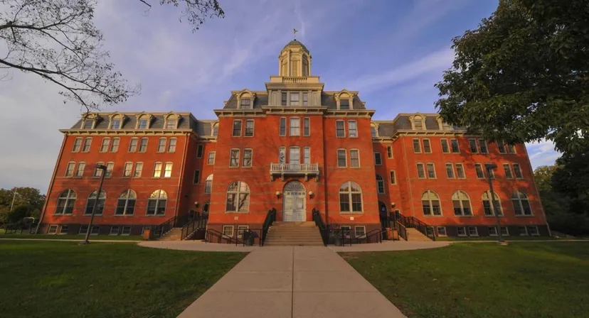 L'edificio in mattoni rossi della Perkiomen School si trova su un prato curato con alberi sullo sfondo.