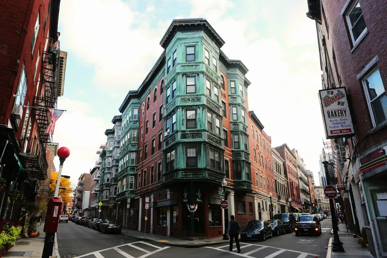 Straßenkreuzung mit Backsteinhäusern und grünem Eckgebäude in einer amerikanischen Altstadt