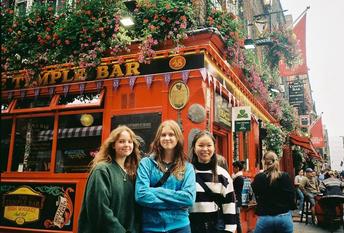 Der Fluss Liffey in Dublin in der Dämmerung mit beleuchteten Häusern und der Fußgängerbrücke