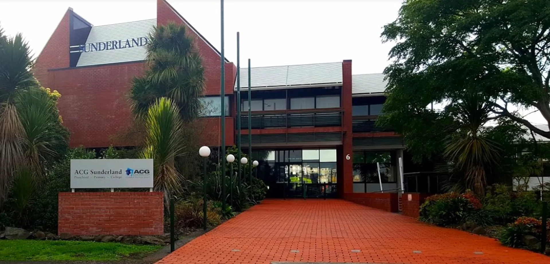 L'edificio in mattoni rossi con la scritta ACG Sunderland è circondato da alberi ed è raggiungibile tramite un sentiero pavimentato.