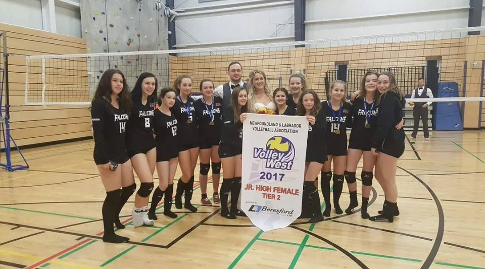 Un gruppo di pallavoliste tiene uno striscione del campionato nella palestra della Pasadena Academy.