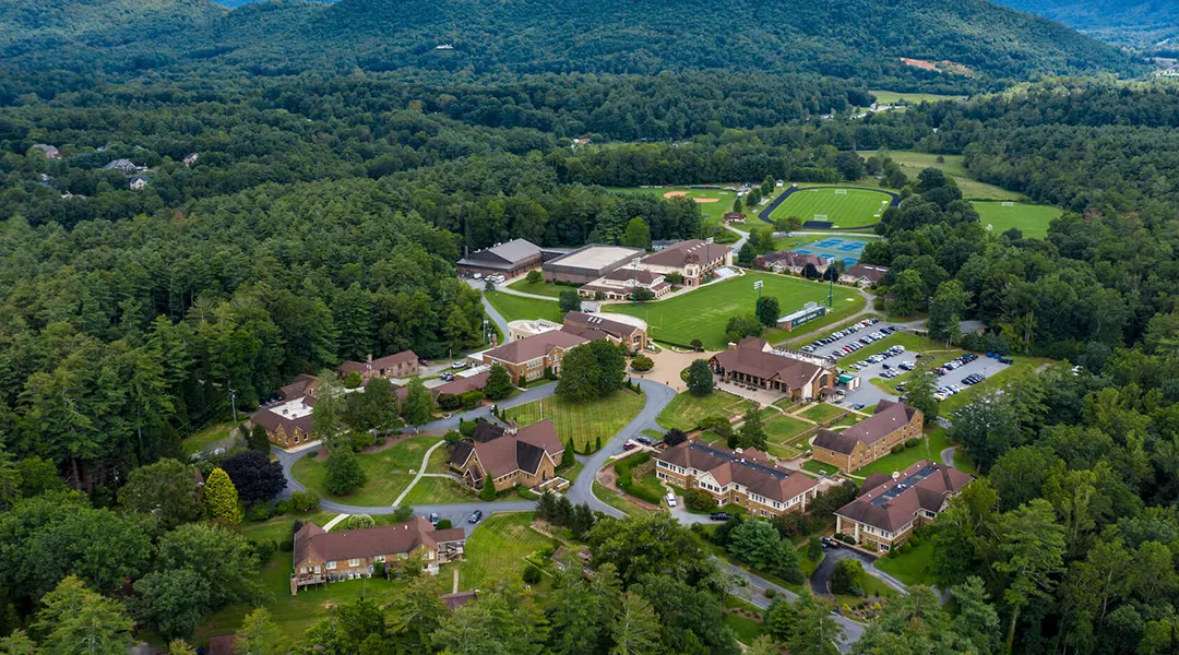 Un pintoresco paisaje de pueblo con bosques verdes y edificios en los terrenos de Christ School.