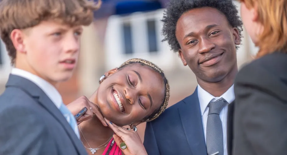 Due uomini in abito formale sono insieme a un evento della St. Christopher School e sorridono.