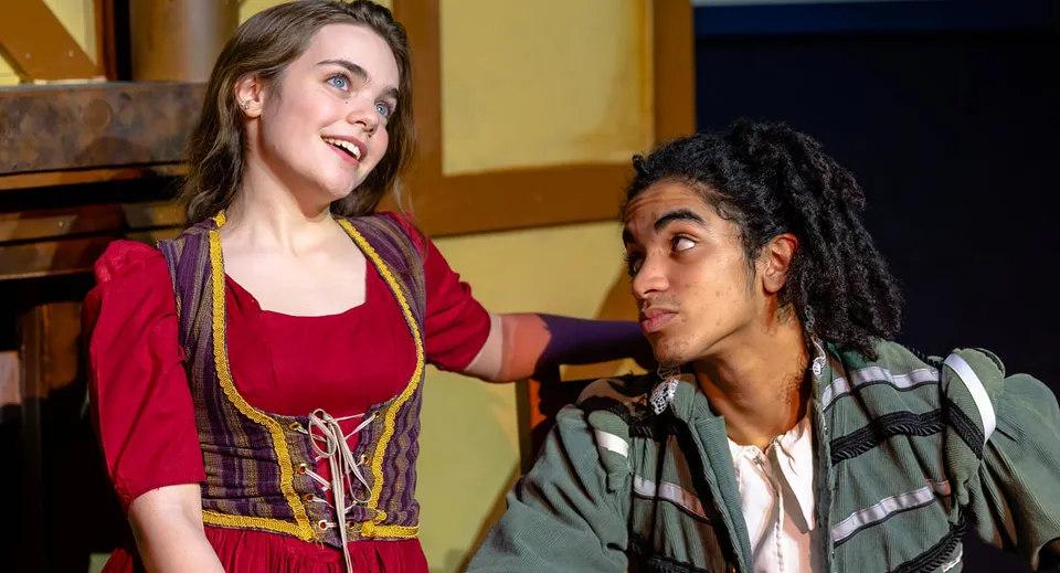 Due studenti della Justin Siena High School chiacchierano e sorridono in una stanza con pareti di legno.