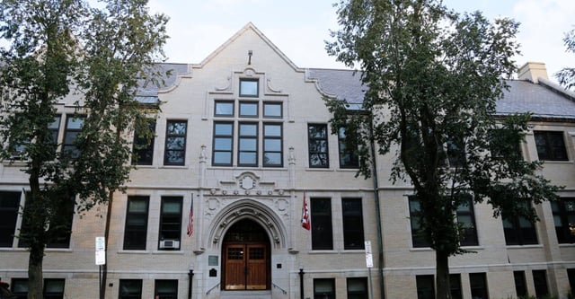 Das gotische Hauptgebäude der Buffalo Seminary ist von grünen Bäumen umgeben.