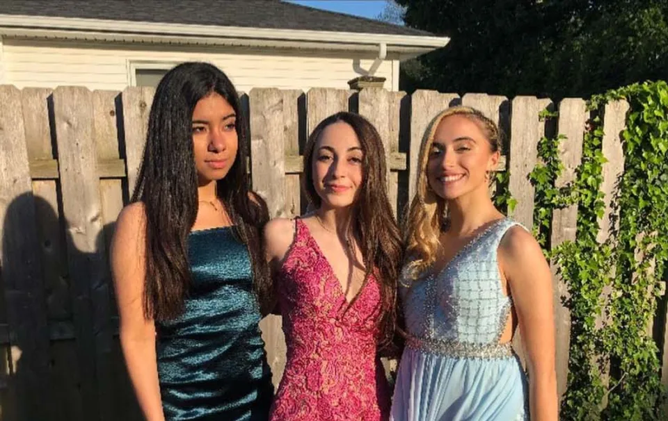 Tre studentesse della Shore Regional High School posano davanti a una staccionata in legno con vegetazione verde sullo sfondo.