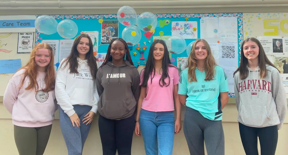 Sei studentesse si trovano insieme in un'aula colorata della St. Louis Secondary School.