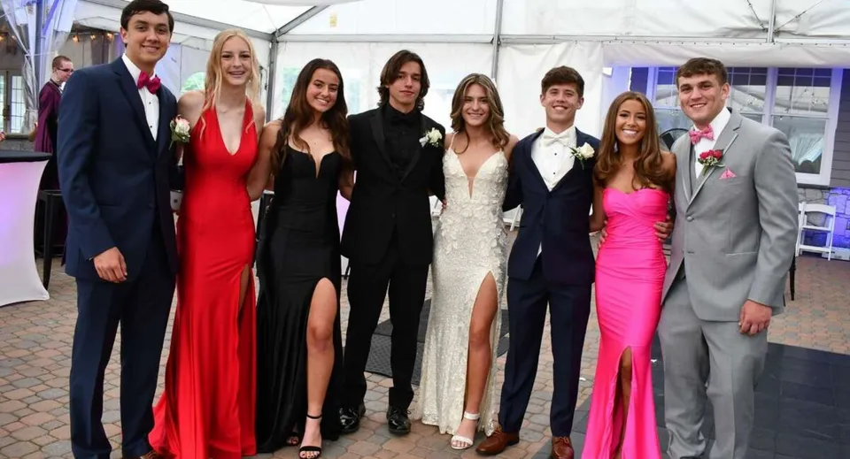 Un gruppo di persone ben vestite posa durante un evento all'interno del campus del Whites Hill State College.