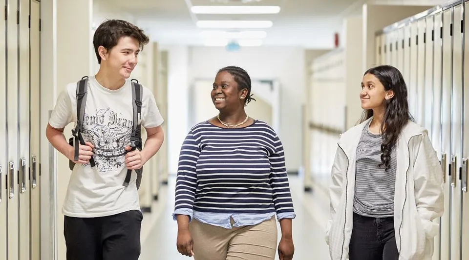 Tre studenti camminano insieme nel corridoio dell'Institut Collégial Vincent Massey Collegiate.