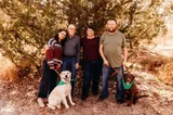 Inés posa con su familia anfitriona y sus dos perros en un camino entre árboles