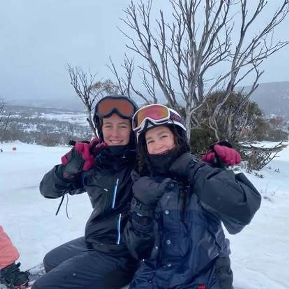 Una donna e un bambino in caldi abiti invernali si trovano in un bosco innevato nella proprietà della Lambton High School.