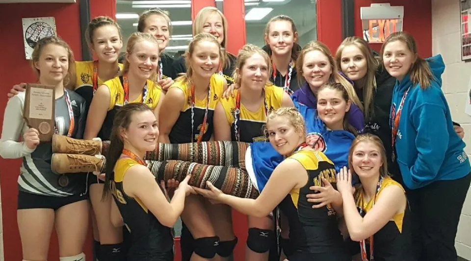 Un gruppo di giovani studentesse della Forestburg School si riunisce sorridente in una palestra.