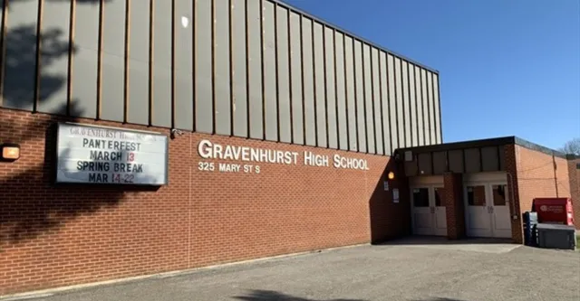 L'edificio in mattoni con l'insegna della Gravenhurst High School e il tabellone con le informazioni sugli eventi.