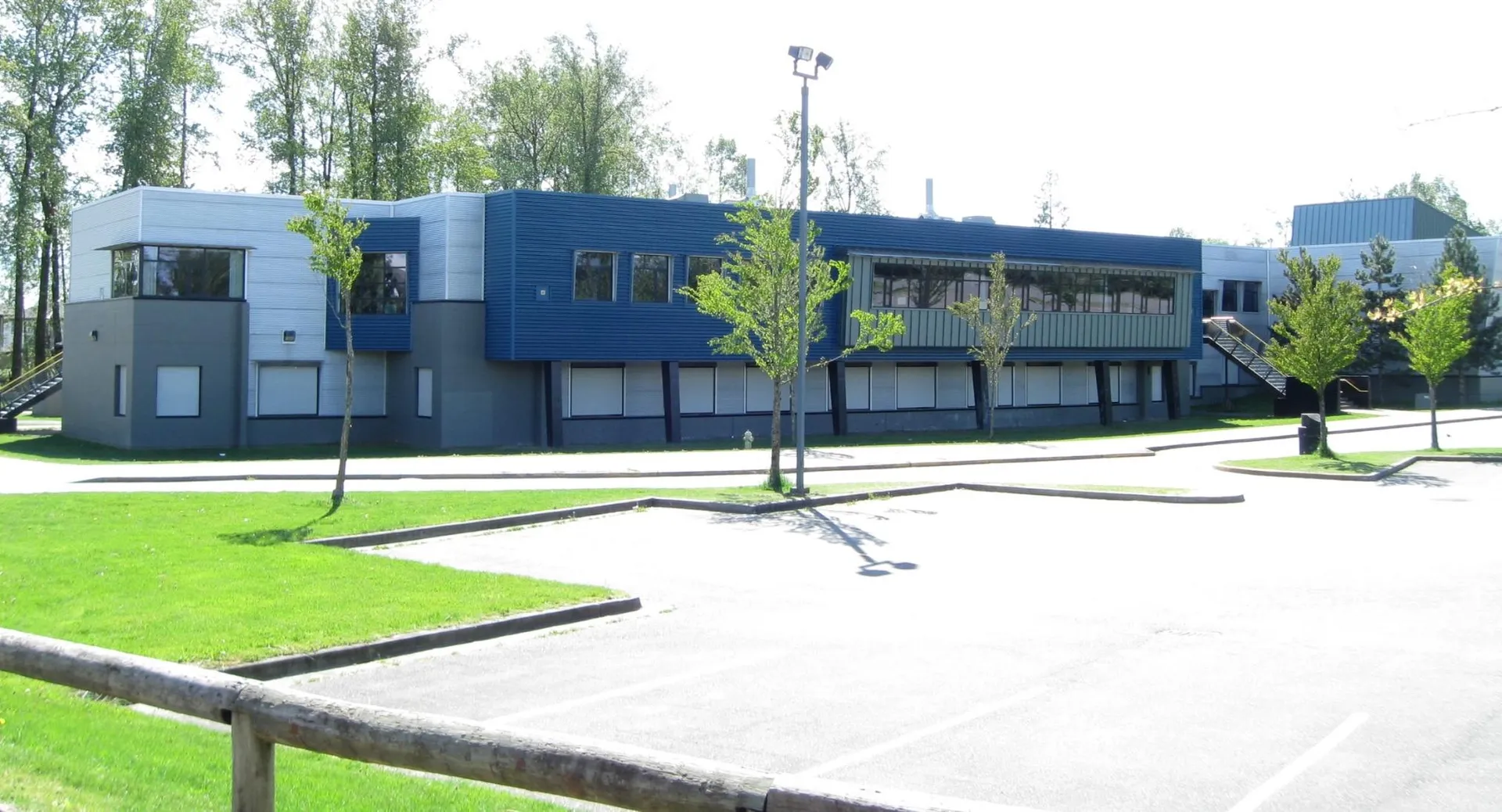 L'edificio moderno a più piani della Clayton Heights Secondary School è circondato da alberi e da un prato.