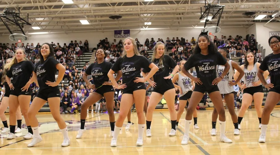 Un gruppo di studentesse in divisa nera si trova sul campo da basket nella palestra della Wyoming High School.