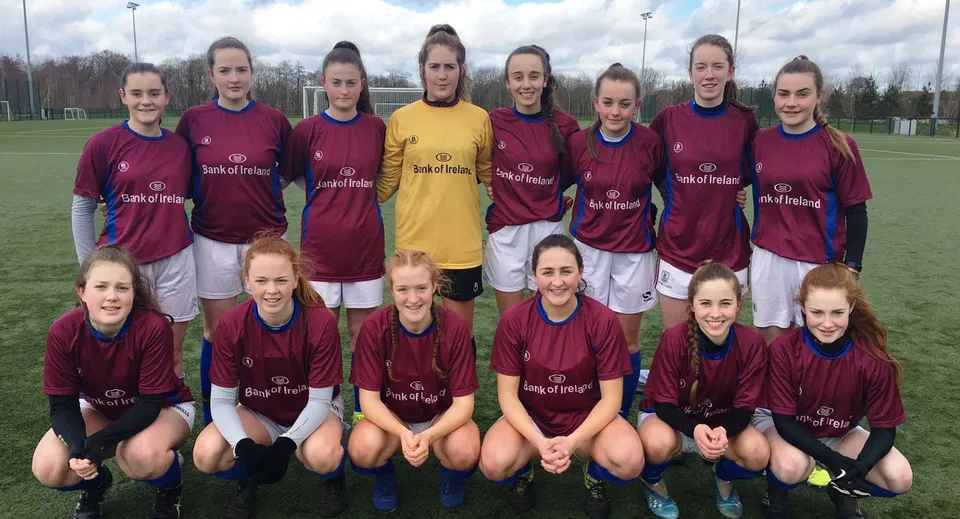 Un gruppo di calciatrici posa nei colori della squadra sul campo sportivo del Galway Community College.