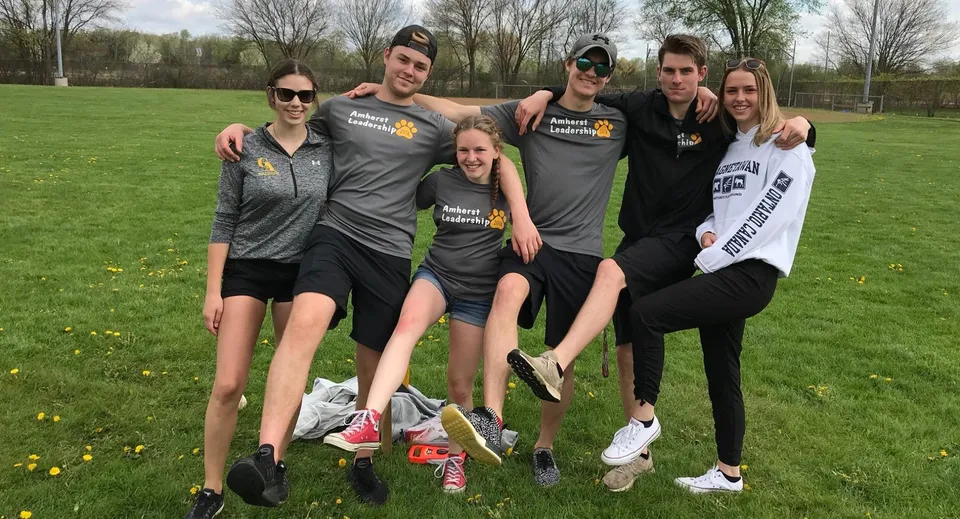 Un gruppo di studenti e studentesse si trova all'aperto sul campo sportivo della North Star High School.