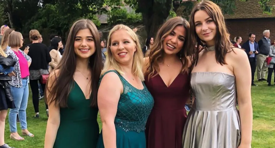 Quattro studentesse della St. Clare’s School in posa insieme nel verde.