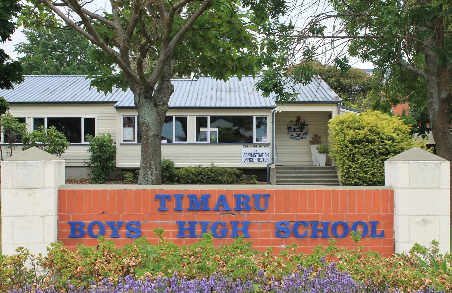 L'edificio in legno con tetto in metallo nel campus della Timaru Boys School è circondato da alberi.
