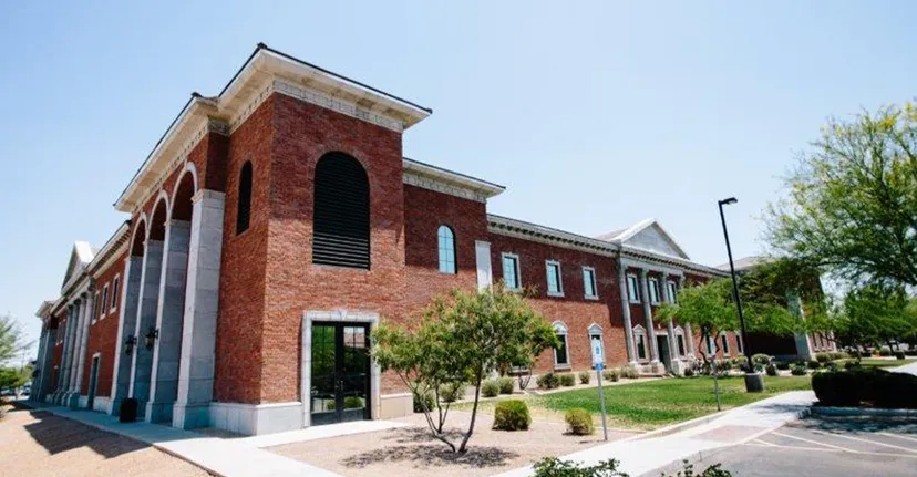 L'imponente edificio in mattoni con archi e ingresso nel campus delle Gilbert Christian Schools è circondato da un paesaggio curato con alberi.