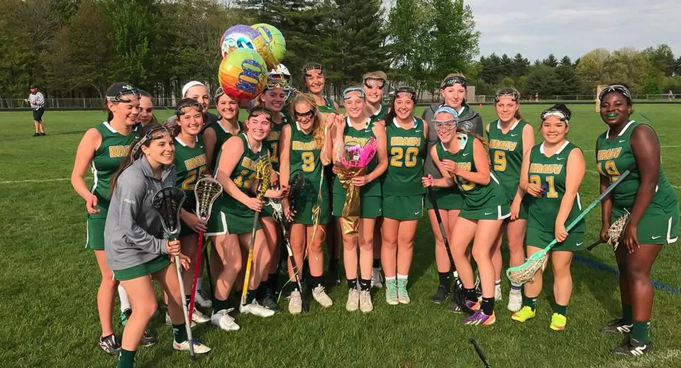 Un gruppo di giovani studentesse della Bishop Brady High School si trova su un campo erboso e tiene un palloncino colorato.