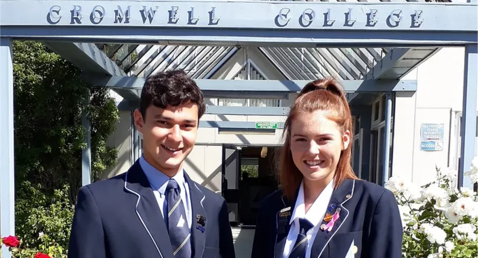 Due studenti e studentesse davanti all'edificio del Cromwell College.