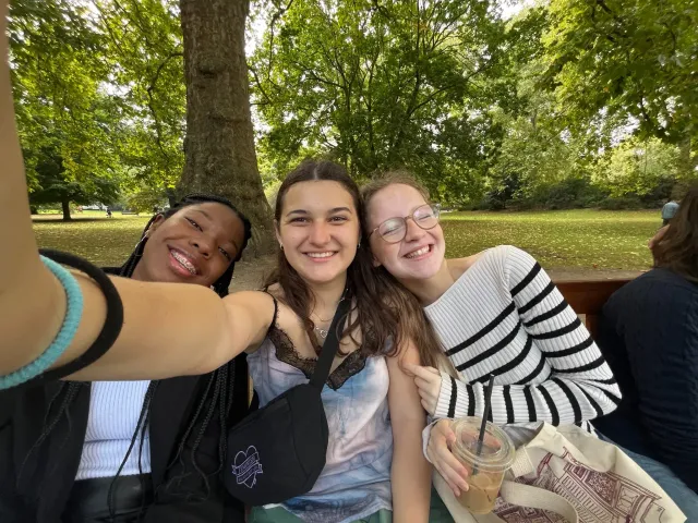 Tre amiche sorridenti che si fanno un selfie in un parco in Gran Bretagna
