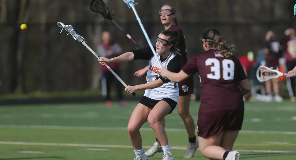 Le studentesse della Marlborough Girls giocano una partita di lacrosse su un campo erboso.