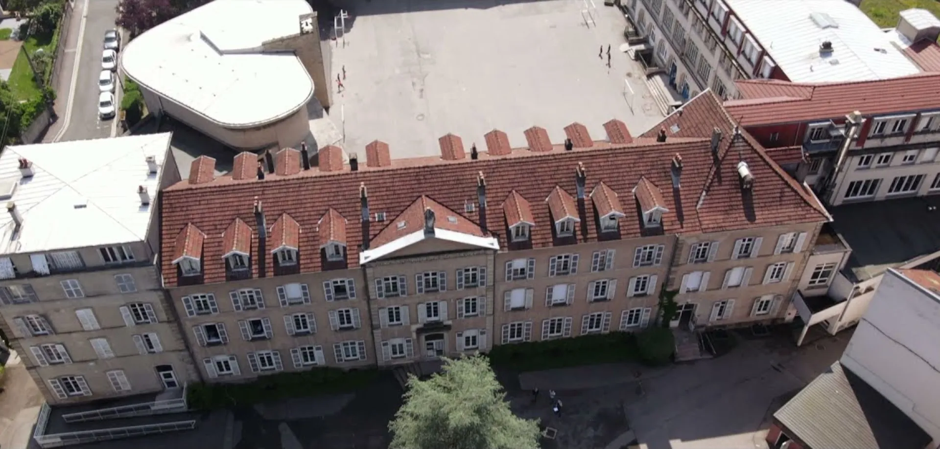 L'edificio storico in mattoni con una particolare linea del tetto nel campus della Notre Dame Saint Joseph School.