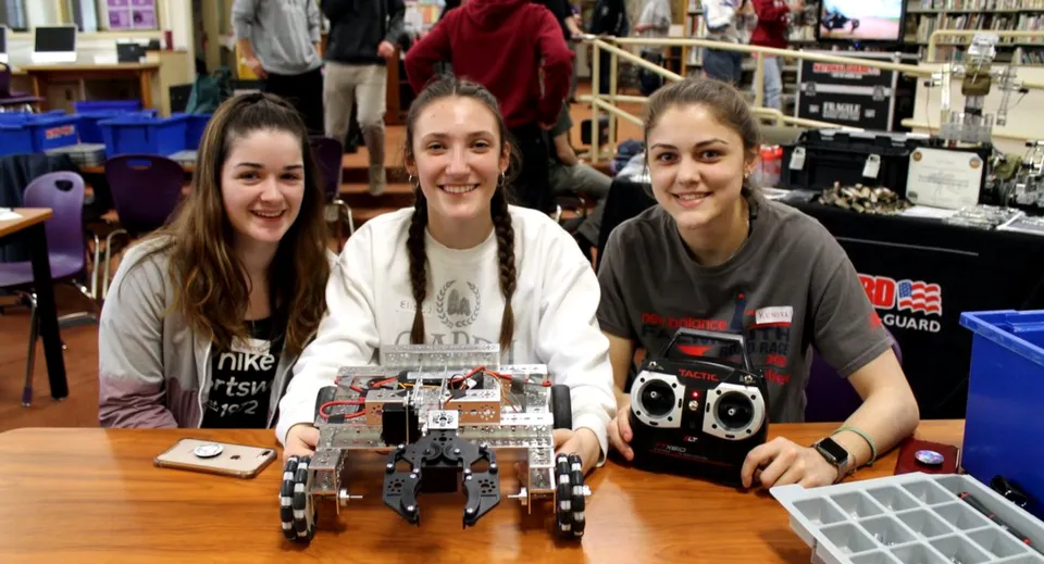 Tre studentesse della Dundalk Grammar School lavorano insieme a un progetto di robotica in un'aula.
