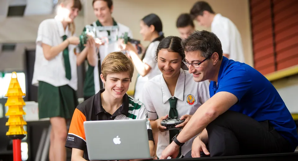 Un gruppo di studenti della Merrimac State High School lavora insieme a un laptop.