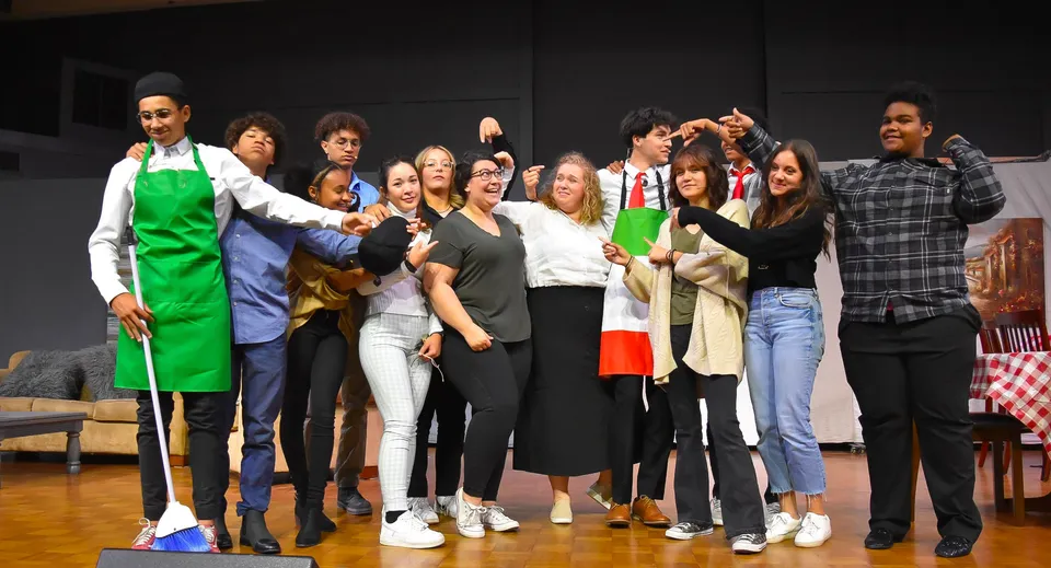 Un gruppo di studenti della Bethel Christian Schools è insieme su un palco davanti a uno sfondo scuro.