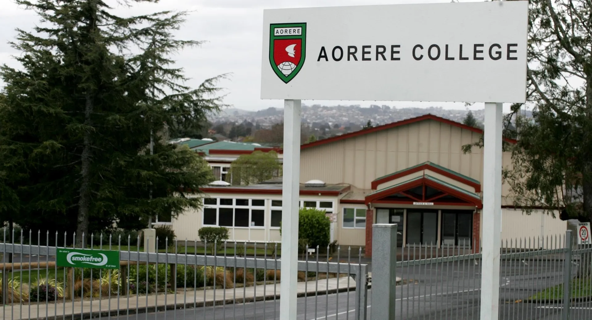 L'ingresso dell'Aorere College con edifici, alberi e un cartello con il nome della scuola.