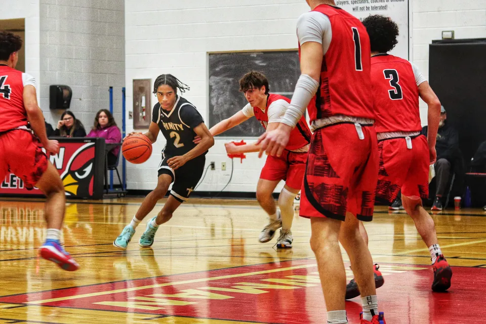 Studenti della Oakville Trafalgar High School giocano una partita di basket su un parquet davanti al pubblico.