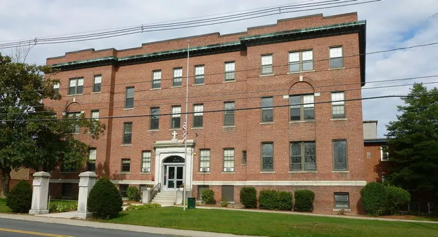 L'edificio in mattoni a più piani con un magnifico ingresso sul campus della Lowell Catholic High School è circondato da un'area verde curata.