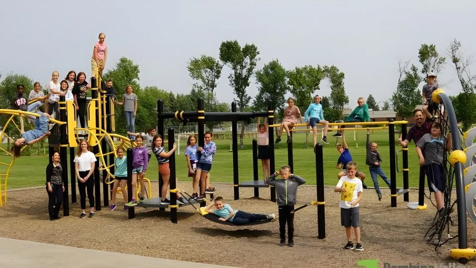 Un grupo de estudiantes juega en el colorido parque infantil en el recinto de la École secondaire publique Rivière Rideau.