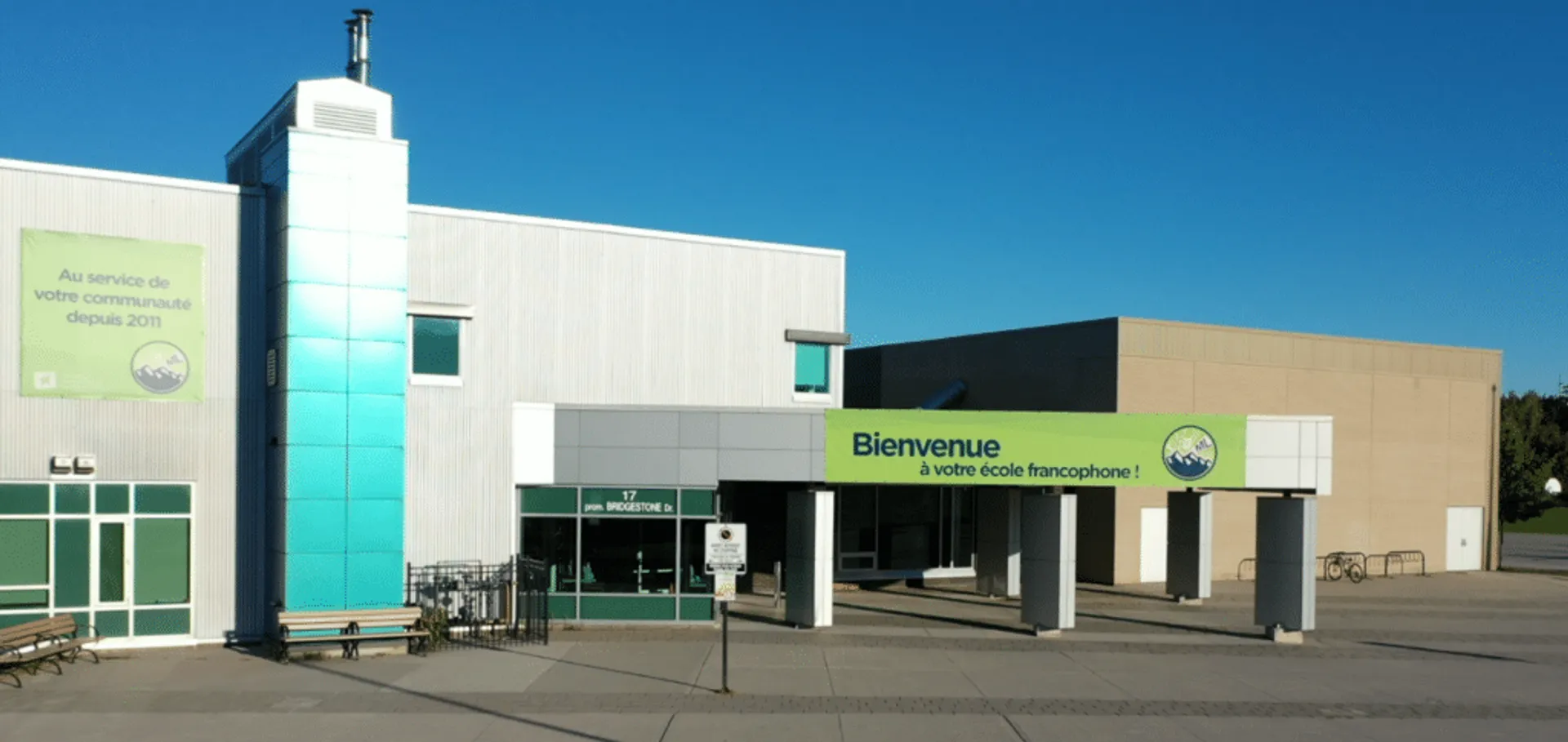 L'edificio principale a più piani della École secondaire publique Maurice Lapointe con un ingresso ben visibile sotto un cielo limpido.