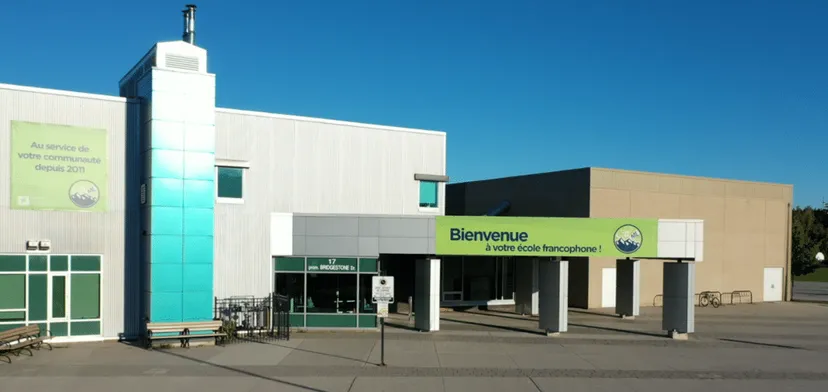 L'edificio principale a più piani della École secondaire publique Maurice Lapointe con un ingresso ben visibile sotto un cielo limpido.