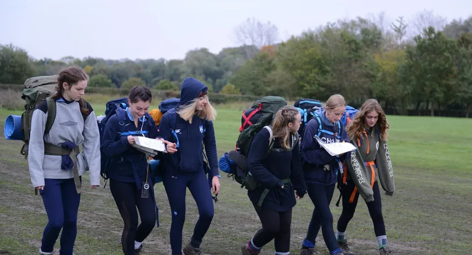 Un gruppo di studenti della King Edward's Witley School si riunisce su un prato circondato dagli alberi.