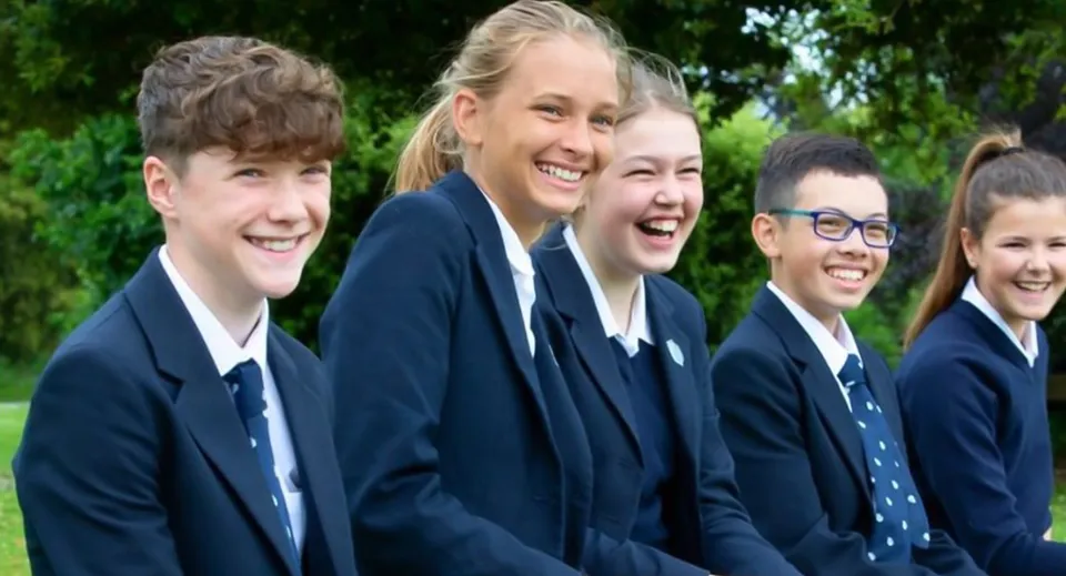 Un gruppo di studenti della Stonar School posa sorridente in un'area verde all'aperto.