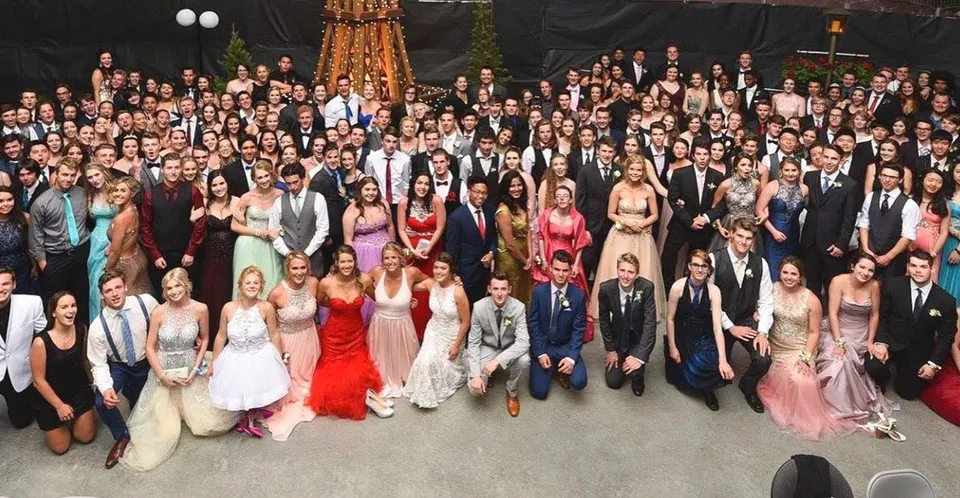 Studenti della Carihi Secondary School si radunano per un'occasione formale in una stanza elegante con lampadario.