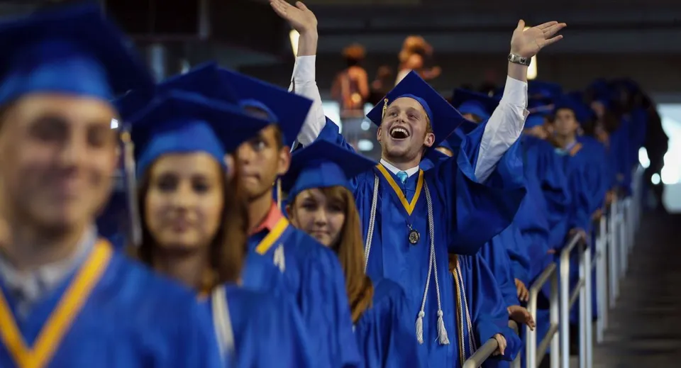 Un gruppo di diplomati della Napanee District Secondary School festeggia il diploma in toga blu.
