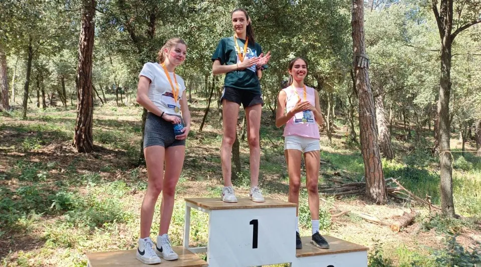 Tre studenti si trovano su un podio in un'area alberata del campus della SEK International School Catalunya.