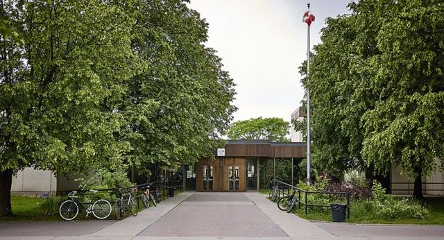 Un viale lastricato con biciclette e alberi nel campus della Colonel By Secondary School.