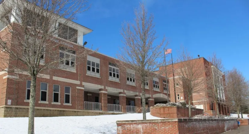 L'edificio in mattoni a più piani della Walpole High School è circondato da un paesaggio innevato e alberi spogli.
