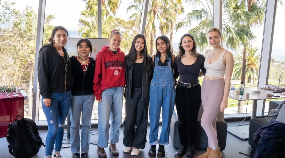 Un gruppo di sei studentesse è in piedi davanti a delle palme nel campus del Santa Barbara City College.