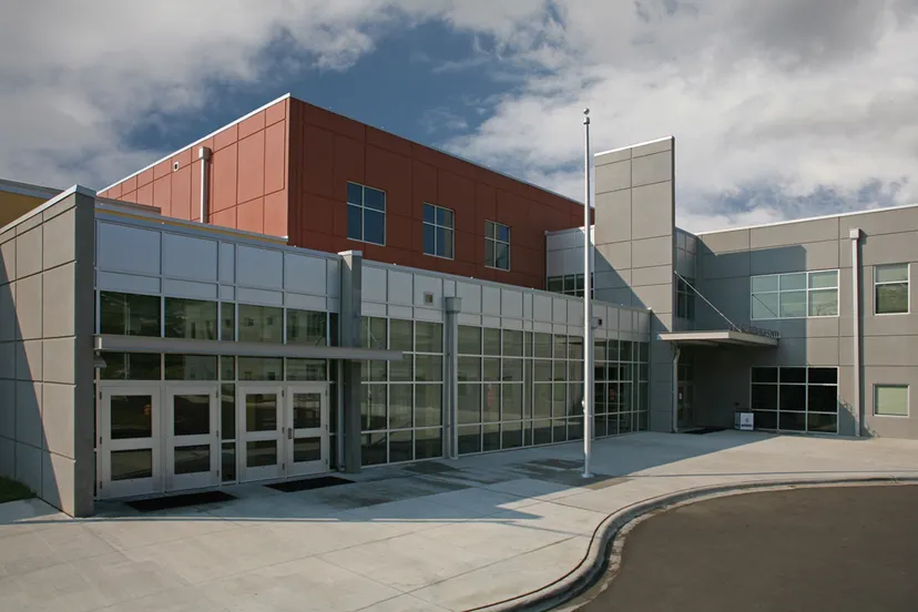 L'edificio principale moderno della Mallard Creek High School con facciata in mattoni e vetro sotto un cielo nuvoloso.