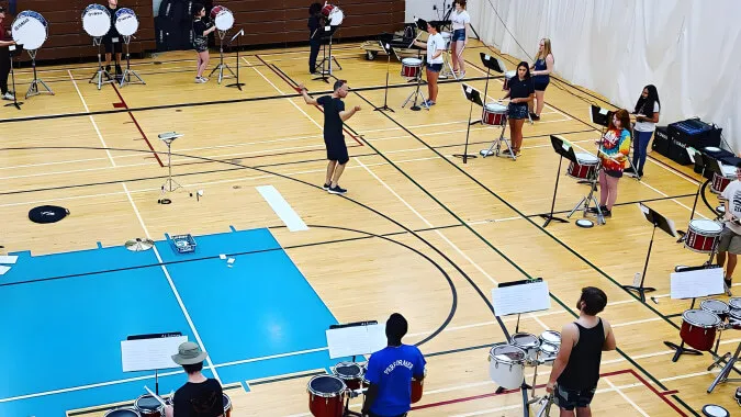 La A.L. Fortune Secondary School muestra una variedad de actividades en su gran gimnasio con campo de baloncesto.