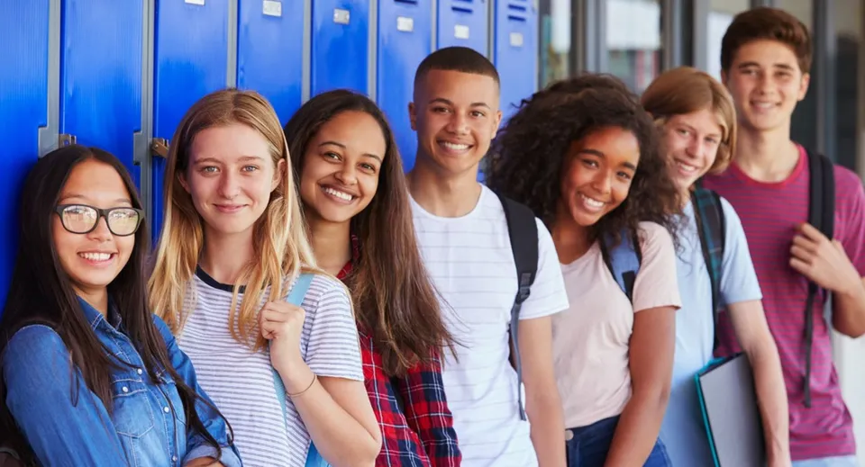 Un gruppo di studenti e studentesse si trova davanti ad armadietti blu nel campus delle Boulder Valley Public Schools.